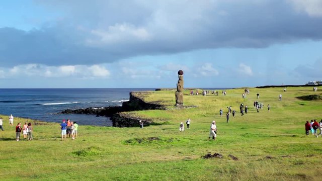 Tourists descend on Easter Island statue.