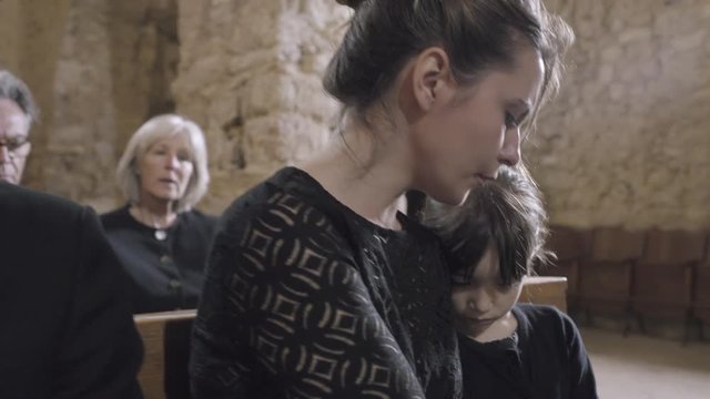 Parents With Child At A Funeral