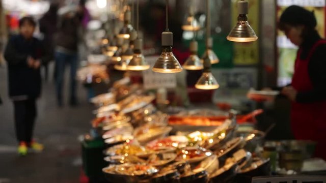 food seller prepares the dishes in Asian fish market.