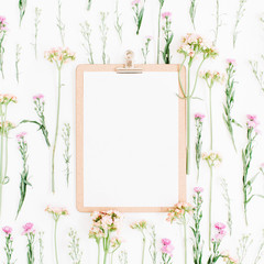 Clipboard mock up and wildflowers pattern. Flat lay, top view