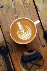 cup of latte art coffee on wooden background