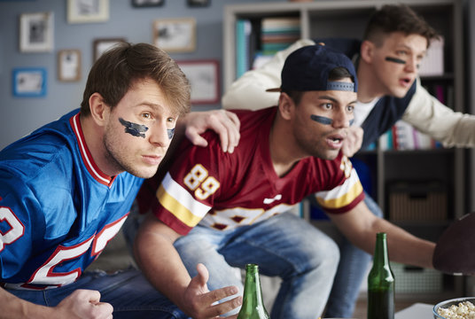 Front view of excited men watching sports game.