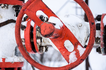 Wellhead valve. Oil and gas concept. Industrial site during winter period.