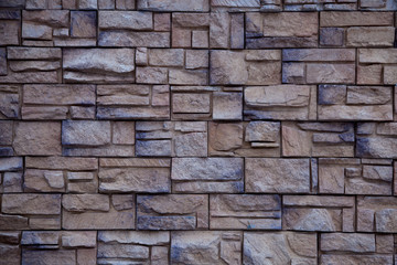 Wall from decorative beige and grey artificial slate stone. Bricks background. Stone texture.
