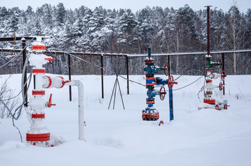 Wellhead valve. Oil and gas concept. Industrial site during winter period.