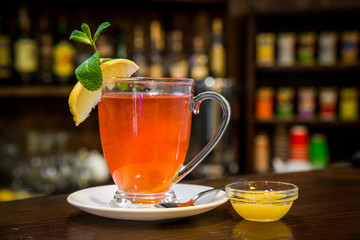 Cup of Hot winter raspberry tea with cinnamon sticks, lemon and star anise