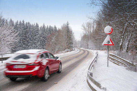 Verschneite Stra&szlig;e mit Auto im Winter