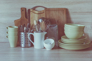 Crockery, tableware, utensils and other different stuff on wooden table-top. Kitchen still life as background for design. Image with copy space. Toned image.