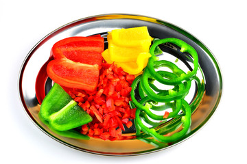 Hintergrundbild für vegane und vegetarische Speisekarte - Rote, grüne und gelbe Paprika am Serviertablett vor weißem Hintergrund