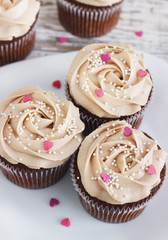 Chocolate cupcakes decorated with cream rose hearts