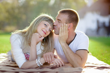 Fototapeta premium husband with the pregnant wife lie on a grass