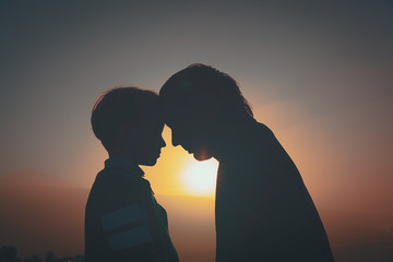 father and little son silhouettes at sunset