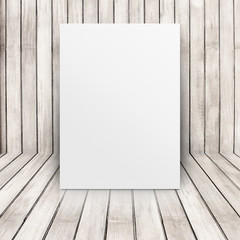 Blank white poster leaning at pale wooden wall on plank floor,Te