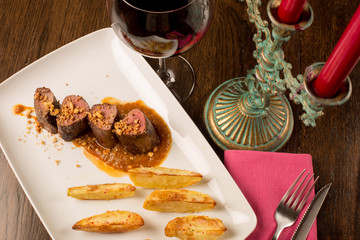 Close up of forest animal steak with potatoes and a glass of win