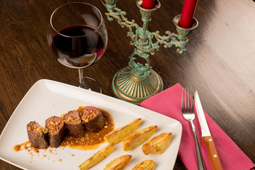 Close up of forest animal steak with potatoes and a glass of win