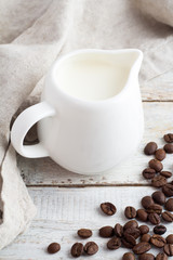 Obraz na płótnie Canvas coffee beans and milk jug on a white background