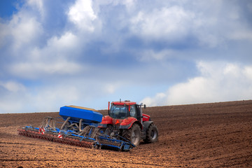 Fototapeta premium Tractor with cultivator handles field before planting. Preparing
