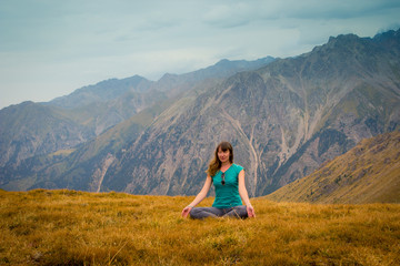 Naklejka na ściany i meble Woman are sitting in yoga style and looking into the distance at