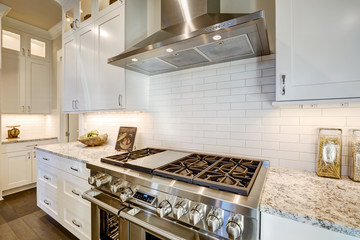 Beautiful kitchen features a nook filled with steel stove