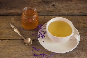 Cup of tea with honey in jar on the wooden table