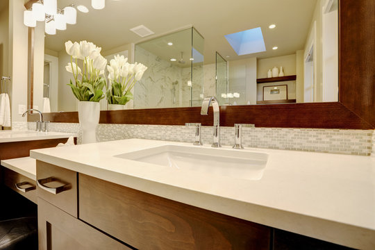 Stunning master bathroom boasts dark brown double sink vanity