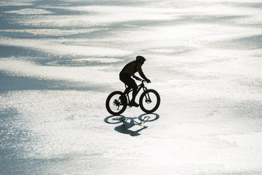 Man cycling on a frozen lake