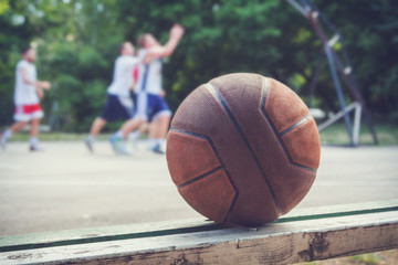 Basketball ball with defocused players in the background.
