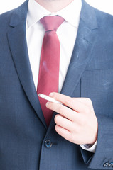 Close-up of man in suit holding a cigarette