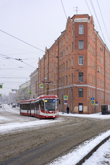 tram rides on road, street, city, old buildings, rails, wires, s