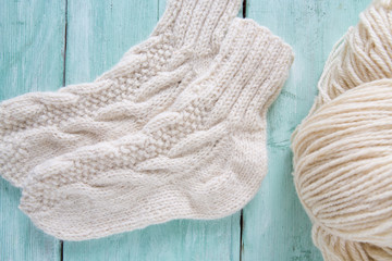 Fototapeta na wymiar knitted socks and yarn on wooden surface