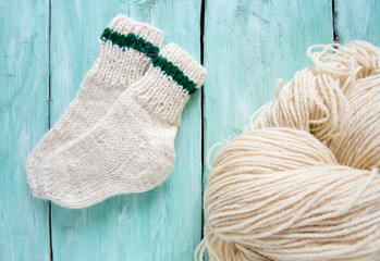 knitted socks and yarn on wooden surface