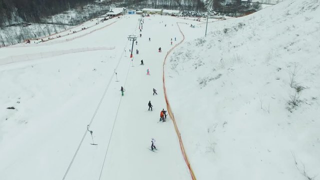 Aerial skiers and snowboarders go up the lift on the slope