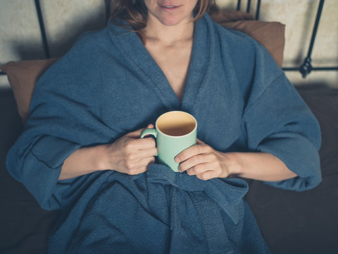 Young woman drinking tea in bed