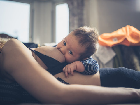 Little baby breastfeeding in bed
