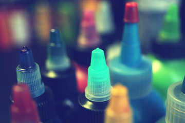 Multiple bottles with colorful inks for tattoo, close up view
