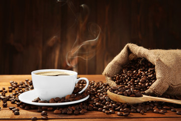 Cup of coffee with beans on table