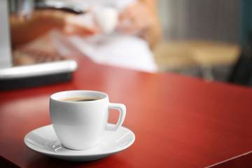 Cup of fresh coffee on kitchen table