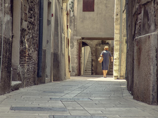 Olld woman in small alley