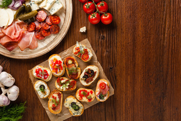 Crostini with different toppings on wooden background. Delicious appetizers. Top view.