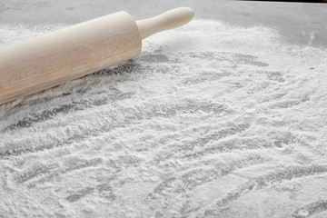 Rolling pin and flour on table