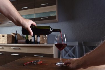 Man pouring red wine into a wineglass