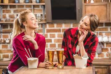 Happy women with noodles and beer