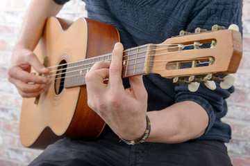 Close-up view of man's hand playing guitar