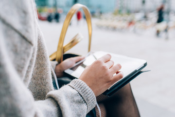 Close up on the hand of young girl tapping the screen of tablet hand hold - technology, social network, communication concept