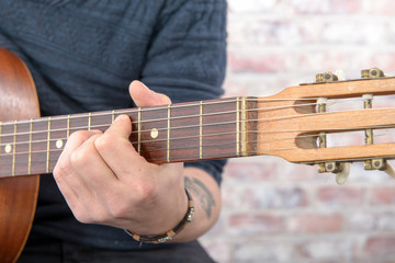 Fototapeta na wymiar Close-up view of man's hand playing guitar
