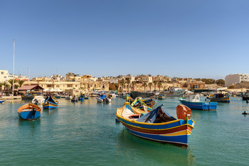 Fototapeta na wymiar Traditional Maltese boats in the harbor of Marsaxlokk , Malta