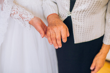 hands at a wedding young and old