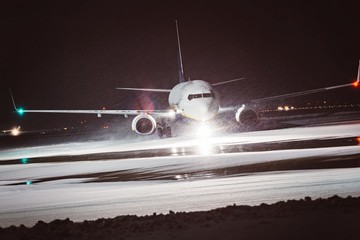 Fototapeta premium Passenger airplane takes off during heavy snow