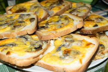 Fette di pancarrè tostate e condite con funghi, formaggio e uovo 