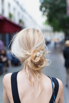 Blond girl with beautiful hair standing on a street of Paris, near the cafe